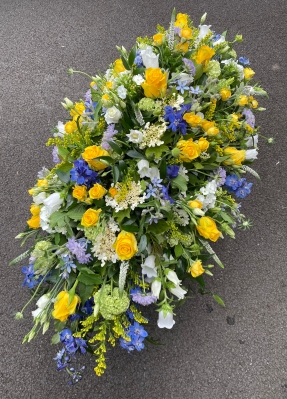 Blue and yellow funeral spray