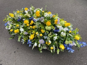 Blue and yellow funeral spray