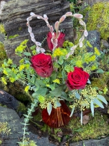 Three red roses in a red glass vase